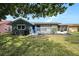 Exterior home view highlighting a yard, grill, front door, and screened-in patio at 4326 Great Lakes N Dr, Clearwater, FL 33762
