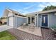 Charming home featuring a front patio with chairs, mosaic tile, and blue accent door at 4326 Great Lakes N Dr, Clearwater, FL 33762