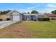 Charming single-story home featuring a well-maintained lawn, attached garage, and cozy front porch seating area at 4326 Great Lakes N Dr, Clearwater, FL 33762