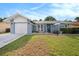 Charming single-story home featuring a well-maintained lawn, attached garage, and cozy front porch seating area at 4326 Great Lakes N Dr, Clearwater, FL 33762