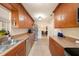 Galley kitchen boasting stainless steel appliances, tile flooring, stone countertops, and wood cabinets at 4326 Great Lakes N Dr, Clearwater, FL 33762