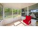 Enclosed patio featuring tile floor, screen door and single red chair with backyard view at 4326 Great Lakes N Dr, Clearwater, FL 33762