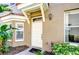 Inviting front entrance with a white door, tiled roof, and lush landscaping at 4968 Anniston Cir, Tampa, FL 33647