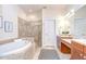 Luxurious main bathroom featuring a soaking tub, a separate glass shower, and a double vanity sink at 4968 Anniston Cir, Tampa, FL 33647