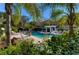 Community pool surrounded by palm trees and lounge chairs, perfect for relaxation at 4968 Anniston Cir, Tampa, FL 33647