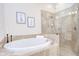 Elegant soaking tub with tile surround and glass shower is perfect for relaxing and unwinding at 4968 Anniston Cir, Tampa, FL 33647