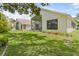 Well-maintained backyard featuring lush grass, manicured landscaping, and screened-in patio area for outdoor relaxation at 521 Bent Oak Ct, Spring Hill, FL 34609