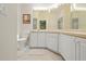 Bathroom with a large mirror, vanity, and cabinets, along with a separate toilet area at 521 Bent Oak Ct, Spring Hill, FL 34609