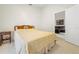 Clean bedroom with neutral carpeting and a peek into the dark leather seating of the living room at 521 Bent Oak Ct, Spring Hill, FL 34609