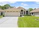 Charming single-story home featuring a two-car garage, well-manicured lawn, and inviting front entrance at 521 Bent Oak Ct, Spring Hill, FL 34609