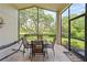 Screened lanai with outdoor dining set and a view of the backyard at 521 Bent Oak Ct, Spring Hill, FL 34609