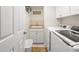 The laundry room includes white appliances, cabinets, and a sink, providing a functional space at 521 Bent Oak Ct, Spring Hill, FL 34609