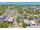 An aerial view showcases the homes proximity to shops, trees, roads, and the beautiful bay waters at 556 Virginia St, Dunedin, FL 34698