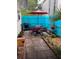 Cozy back patio featuring an umbrella table, grill, and a vibrant blue fence at 556 Virginia St, Dunedin, FL 34698