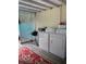 Outdoor laundry area with a washer and dryer on a covered patio with a decorative rug at 556 Virginia St, Dunedin, FL 34698
