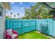 Private backyard featuring artificial turf, a privacy fence, and additional backyard storage at 556 Virginia St, Dunedin, FL 34698