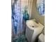 Neat bathroom featuring a vanity, a decorative shower curtain, and matching coral-themed rug at 556 Virginia St, Dunedin, FL 34698