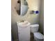 Well-kept bathroom featuring a modern toilet, a vanity, and an oval mirror at 556 Virginia St, Dunedin, FL 34698