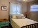 Comfortable bedroom featuring bright curtains, soft lighting, and a stylish, well-made bed at 556 Virginia St, Dunedin, FL 34698