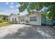 Charming house boasts ample parking, mature landscaping, and a cheerful exterior, ideal for comfortable living at 556 Virginia St, Dunedin, FL 34698
