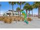 Fun dolphin statue stands near a marina, featuring palm trees and a yacht, perfect for waterfront enjoyment at 556 Virginia St, Dunedin, FL 34698