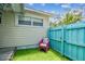 Quaint side yard with artificial turf, privacy fence, and a charming decorative chair at 556 Virginia St, Dunedin, FL 34698