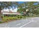 Street view of businesses under shady trees with a railroad crossing sign at 556 Virginia St, Dunedin, FL 34698