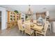 Dining area boasts an antique cabinet, chandelier, and seating for six next to breakfast bar at 5785 15Th N Ave, St Petersburg, FL 33710