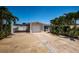 Charming single-story home featuring a one-car garage, covered parking, and tropical landscaping at 5785 15Th N Ave, St Petersburg, FL 33710