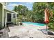 Secluded backyard oasis featuring a refreshing pool, lush landscaping and a green painted house at 6006 N Highland Ave, Tampa, FL 33604