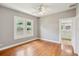 Bright bedroom featuring hardwood floors, neutral walls, and a bathroom across the hall at 6006 N Highland Ave, Tampa, FL 33604