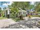 Green home showcasing its driveway, lovely yard plants, and a view of the neighbor's house at 6006 N Highland Ave, Tampa, FL 33604