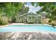 Inviting pool with brick trim, adjacent to the green house and mature trees at 6006 N Highland Ave, Tampa, FL 33604