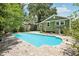 Sparkling pool surrounded by lush landscaping and a green painted house at 6006 N Highland Ave, Tampa, FL 33604
