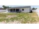 View of the home's backyard showing the enclosed porch and white fencing at 6110 16Th St, Zephyrhills, FL 33542