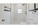 Well-lit bathroom featuring rainfall shower, white subway tile and sleek black hardware at 6110 16Th St, Zephyrhills, FL 33542