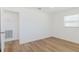Minimalist bedroom with wood-look flooring and a window, offering a serene retreat at 6110 16Th St, Zephyrhills, FL 33542