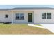 Close up of the front of the home showing an inviting entryway and landscaping at 6110 16Th St, Zephyrhills, FL 33542