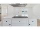 Kitchen island with cooktop, quartz countertop, white cabinetry and stainless steel range hood at 6110 16Th St, Zephyrhills, FL 33542