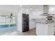 Open kitchen with stainless appliances, white cabinetry, quartz countertops, and view of backyard at 6110 16Th St, Zephyrhills, FL 33542