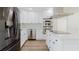 Charming kitchen with stainless steel appliances, white cabinets, quartz countertops, and designer backsplash at 6110 16Th St, Zephyrhills, FL 33542
