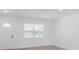 Bright living room with white walls, luxury vinyl plank flooring, and a window overlooking the yard at 6110 16Th St, Zephyrhills, FL 33542