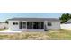 Home featuring a screened-in porch and concrete patio in the backyard at 6110 16Th St, Zephyrhills, FL 33542