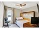 Cozy bedroom featuring a murphy bed, adjacent desk and a ceiling fan at 7114 Fern Garden Ct, Sun City Center, FL 33573