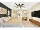Spacious bedroom features carpet, ceiling fan, accent furniture, accent lighting and views of a walk-in closet at 7114 Fern Garden Ct, Sun City Center, FL 33573