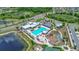 A high angle view of the community pool, clubhouse and recreation area surrounded by lush landscaping at 7114 Fern Garden Ct, Sun City Center, FL 33573