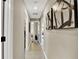 Hallway with neutral paint, tile flooring, and contemporary artwork leading to multiple rooms at 7114 Fern Garden Ct, Sun City Center, FL 33573