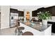 Modern kitchen featuring dark wood cabinets, granite countertops, stainless steel appliances, and a center island at 7114 Fern Garden Ct, Sun City Center, FL 33573