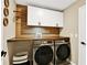 Well-organized laundry room with white cabinetry, butcher block countertop, and side-by-side washer and dryer at 7114 Fern Garden Ct, Sun City Center, FL 33573
