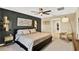 Beautiful main bedroom with dark accent wall, luxury furnishings and ceiling fan at 7114 Fern Garden Ct, Sun City Center, FL 33573